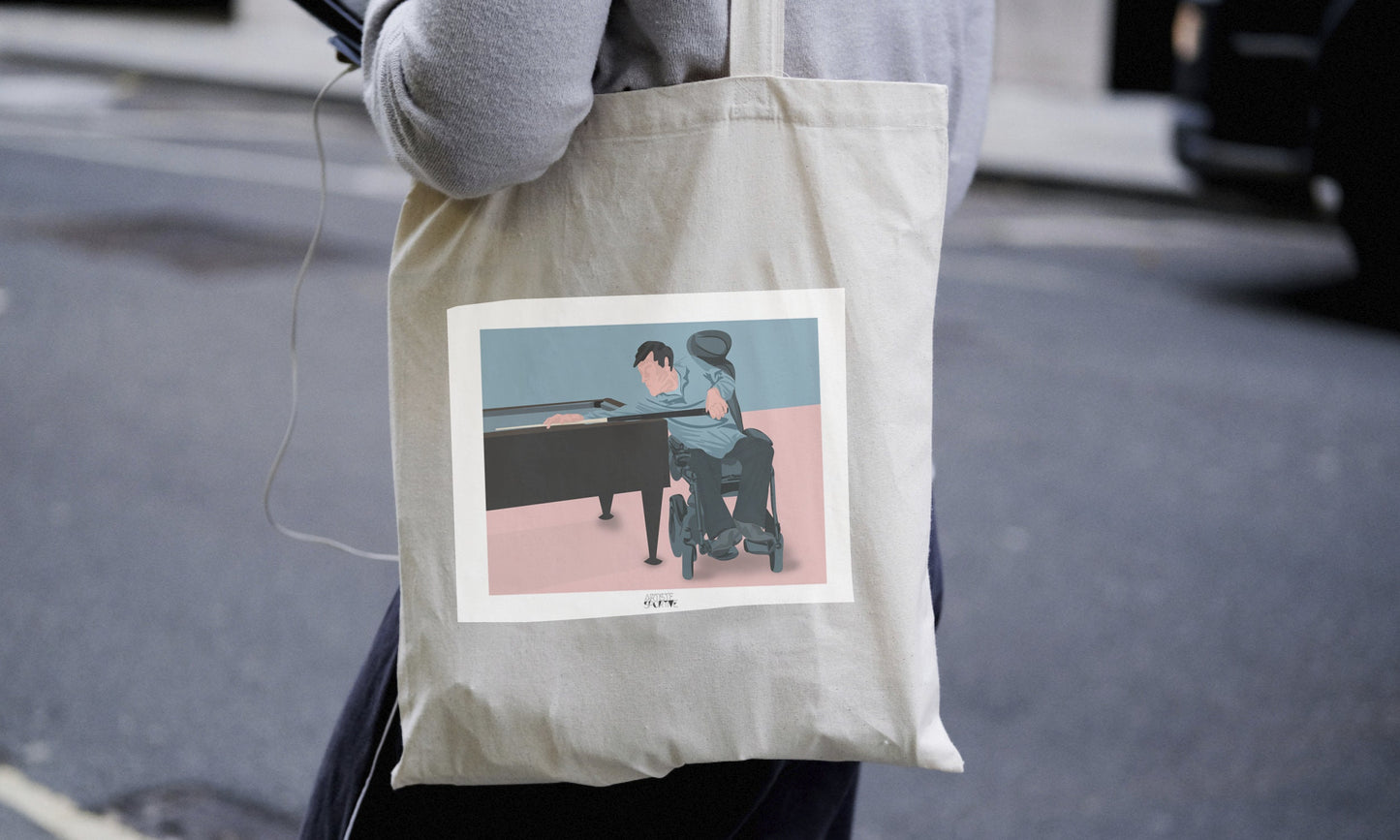 a person carrying a tote bag with a picture of a man playing a piano